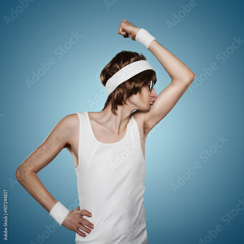 Poster Funny retro nerd kissing his biceps isolated on blue background