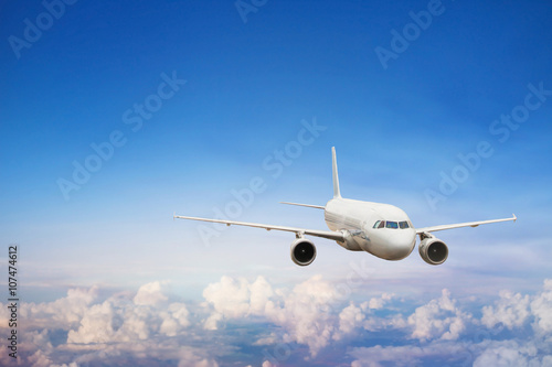 travel by plane, international flight, airplane flying in blue sky above the clouds