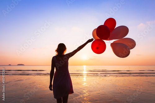 Poster imagination and creativity, girl with multicolored balloons at sunset with copys