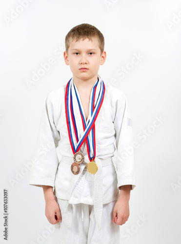 Karate boy in white kimono with medals fighting © volkovslava