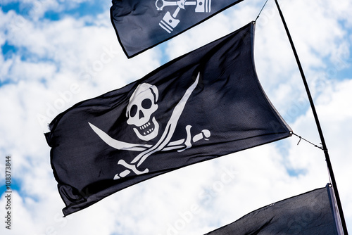 Poster Pirate flags in the wind on a blue sky flags in the wind on a blue sky