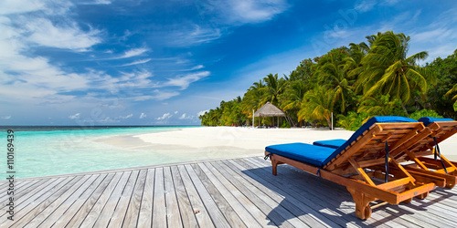 Fotografiet sun lounger bed on jetty in front of paradise island and beach / Sonnenliege auf