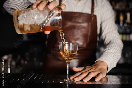 Zdjęcia barman pouring alcoholic cocktail in glass