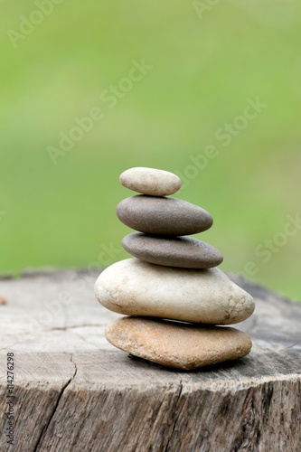 Poster Balance Stones stacked to pyramid in the soft green background.