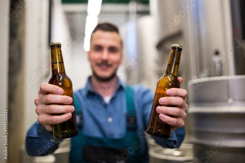 Plagát, Obraz Brewer holding two beer bottle