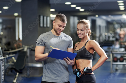 Zdjęcia smiling young woman with personal trainer in gym