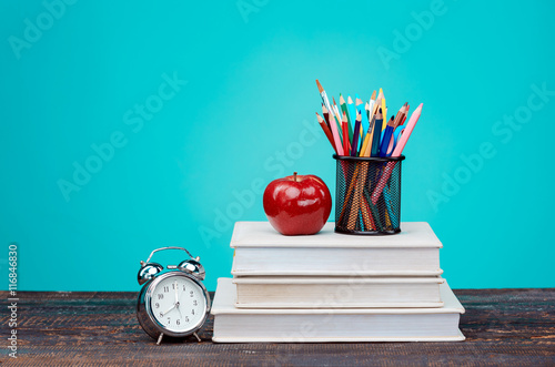 Poster Back to School concept. Books, colored pencils and clock