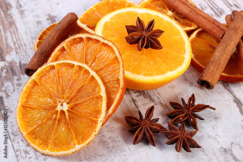 Dried and fresh orange with spices on old wooden background