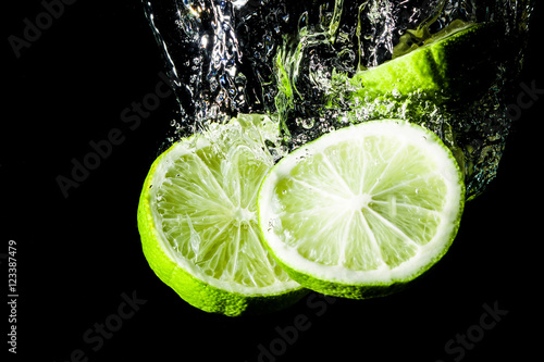 Lemon slice splashing into water.