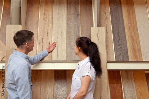 Couple looking at parquet board for home flooring in store