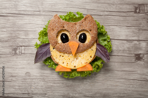 Owl made of bread and cheese on wooden background