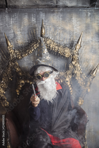 Poster
wizard Merlin conjures and casts a spell, raising his wand, a old man dressed