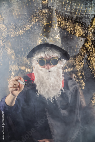 Poster
wizard Merlin conjures and casts a spell, raising his wand, a old man dressed