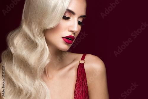 Beautiful blonde in a Hollywood manner with curls, red lips, red lingerie