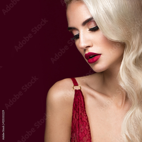 Beautiful blonde in a Hollywood manner with curls, red lips, red lingerie