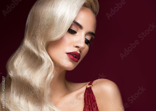 Beautiful blonde in a Hollywood manner with curls, red lips, red lingerie