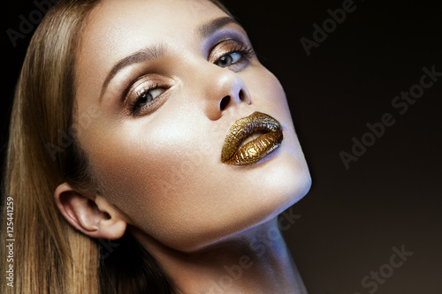 Poster Beautyful girl with gold glitter on her face and body