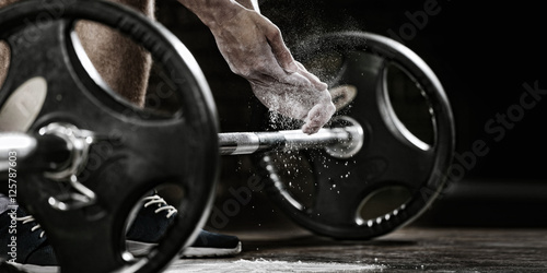 fondo-deportivo-joven-atleta-preparandose-para-el-entrenamiento-de-levantamiento-de-pesas-powerlifter-mano-en-talco-preparandose-para-press-de-banca