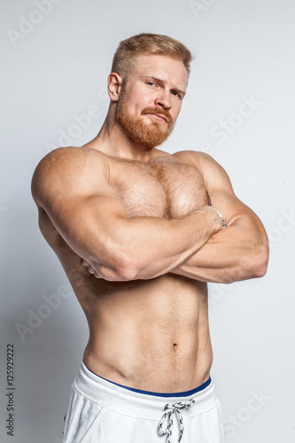 Poster young caucasian muscular bearded man isolated on studio background