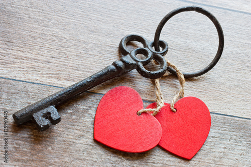 Poster Key with two hearts as a symbol of love on the wooden background