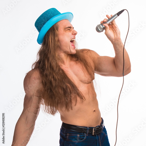 Poster singer bodybuilder shirtless with long hair in a blue hat with a microphone on a