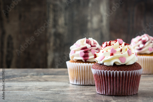Poster Valentine cupcakes decorated with sweet hearts on wooden table