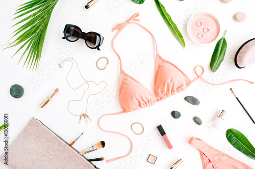 female summer bikini swimsuit and accessories collage on white with palm branches, necklace and sunglasses. flat lay, top view
