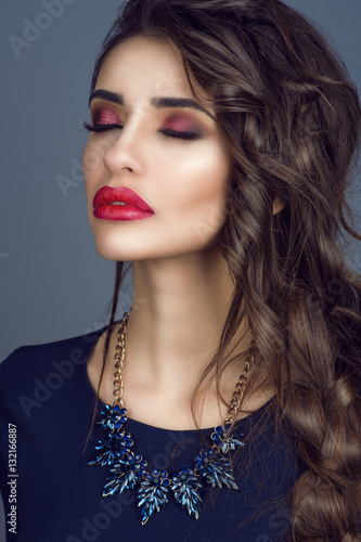 Poster Portrait of gorgeous young lady with perfect skin, red filled lips and long plaited dark hair standing with closed eyes