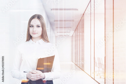 Young girl in an office suit is holding a black folder and standing in a white office corridor with conference rooms. 3d rendering. Mock up. Toned image. Double exposure