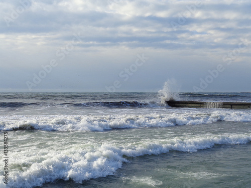 Winter storm at the Black sea, waves splashing on the pier