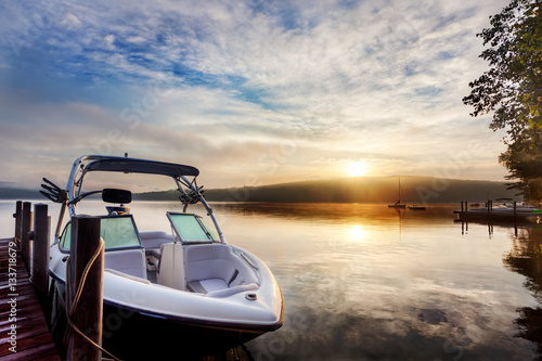 Sun and mist on boat dock at sunrise on a summer day. Merrymeeting Lake, New Hampshire