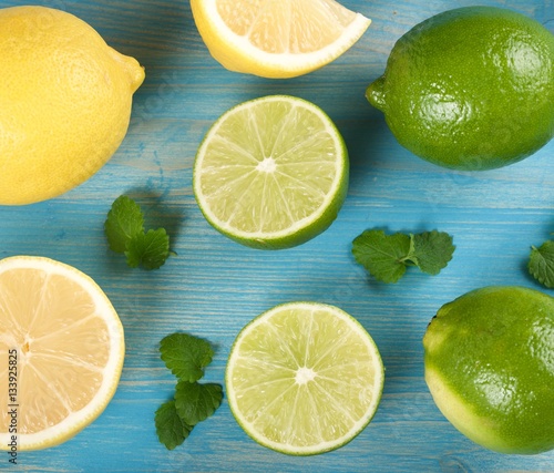 limes and lemons on a wooden background