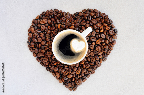 antecedentes-del-cafe-dia-de-san-valentin-granos-de-cafe-en-forma-de-corazon-y-una-taza-de-cafe-recien-hecho