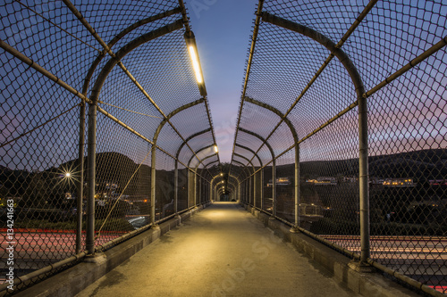 Poster Pedestrian Footbridge with Long Exposure of US 101 Traffic Lights During Sunset