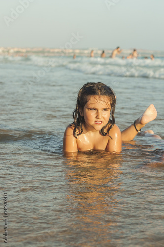 Girl swiming and playing in the seashore of the beach