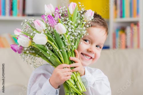 kleiner junge mit tulpenstrauß zum muttertag