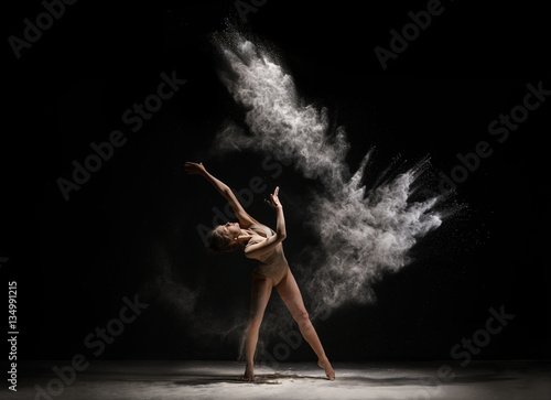 Obraz na płótnie Slender blonde dancing in white dust studio shot
