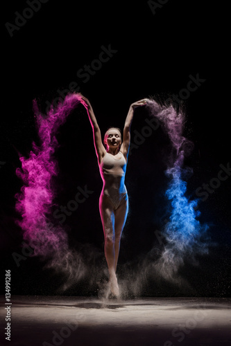 Obraz na płótnie Graceful girl posing in cloud of color dust