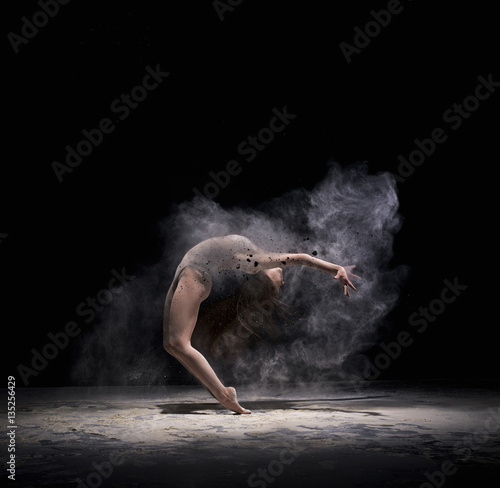 Obraz na płótnie Graceful woman dancing in cloud of white dust