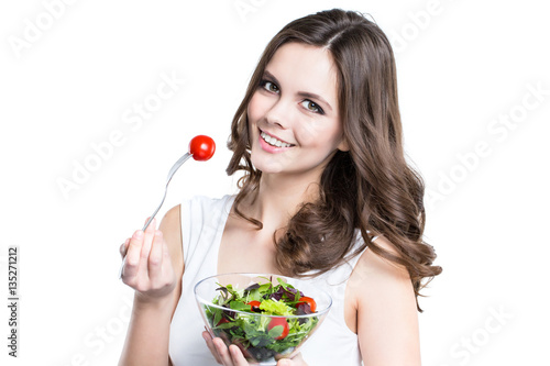 Close-up of pretty girl eating fresh vegetable salad.
