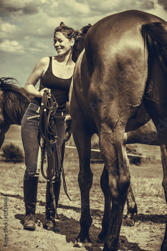 Jockey woman taking care of horse