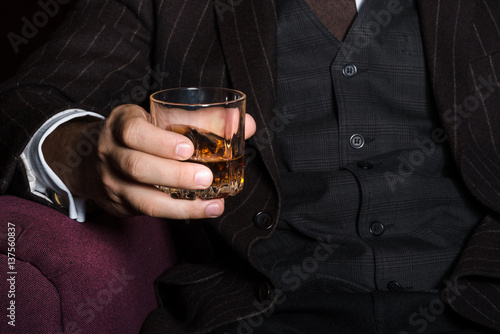 Closeup of serious businessman holding whiskey illustrate executive privilege concept