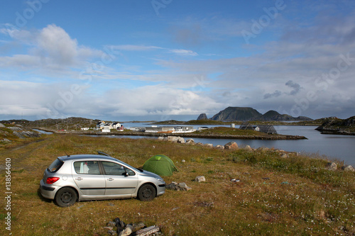 Poster Auto und Zelt auf einer Wiese an einer Bucht mit Inselchen, im Hintergrund Gjesvaer und die Insel Storstappen in der Nähe des Nordkapp