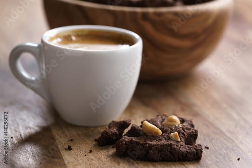 Poster cup of fresh espresso with homemade chocolate cookie with hazelnuts, shallow foc