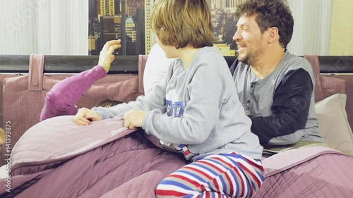 Family having pillow fight in bed slow motion