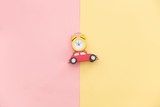 photo of car shaped toy and alarm clock on the wonderful background in pop art style