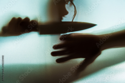 Poster der Schatten einer Frau mit einem Messer ist im Gegenlicht zu sehen