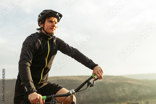 Young male riding bicycle among mountains
