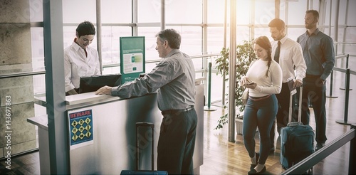 People waiting in queue at airplane counter