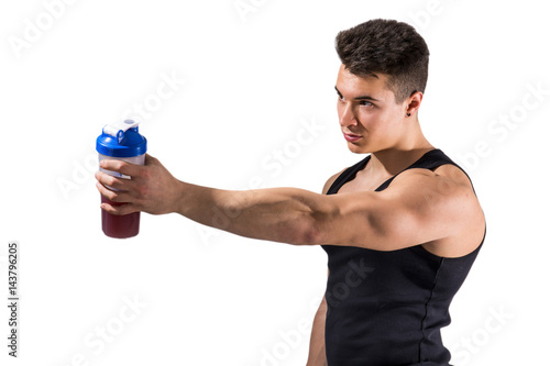Poster Muscular young male bodybuilder holding protein shake bottle, drinking